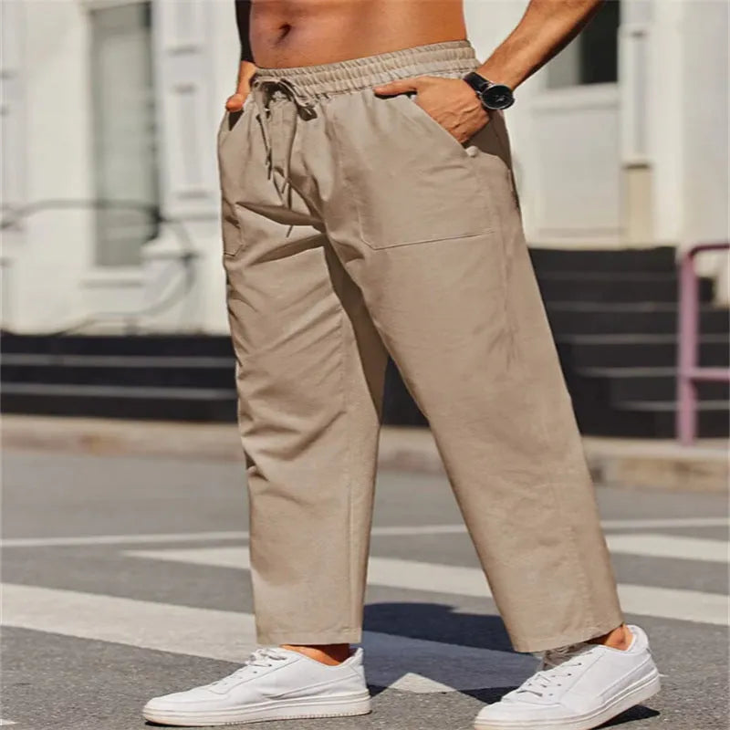 Men's straight-leg linen trousers in a solid colour, showing the elasticated mid waist and long leg.