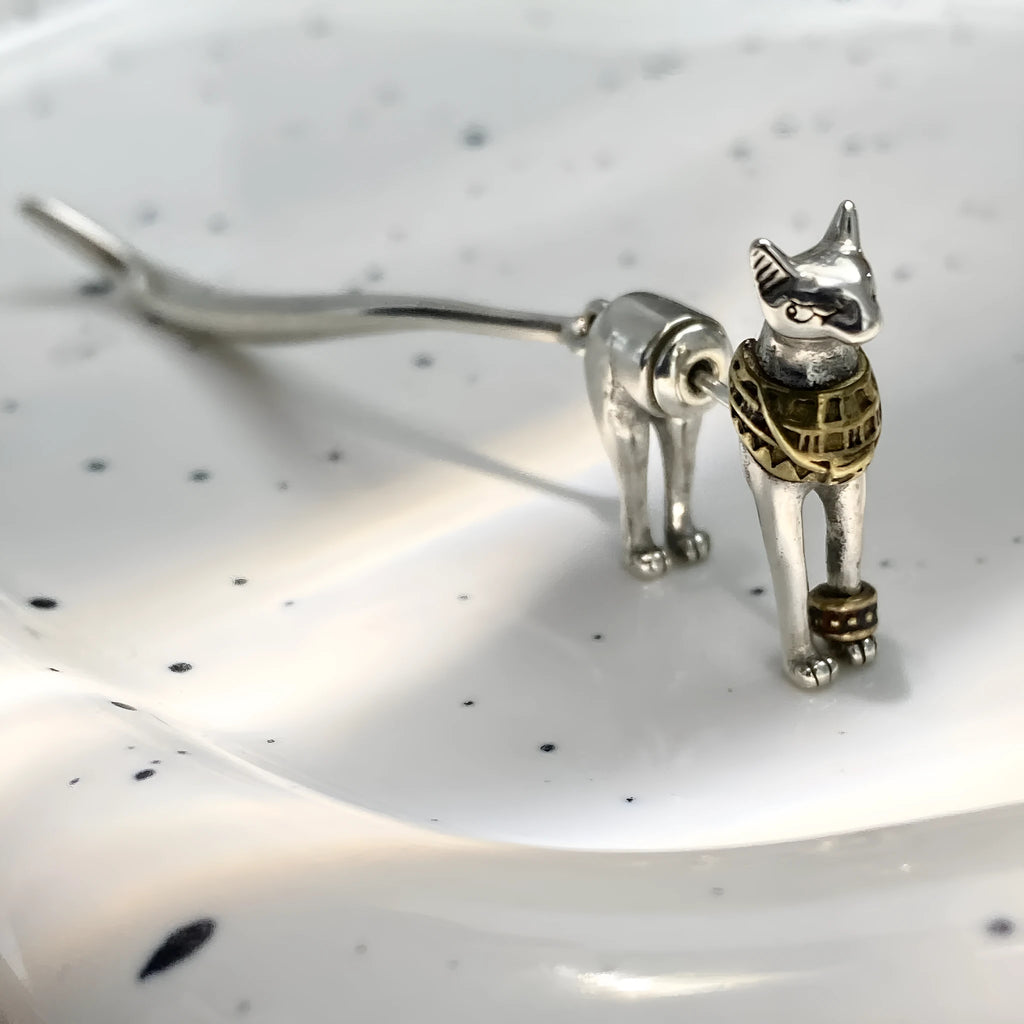 Single copper earring with pharaoh cat shape, gold and silver two-tone copper plated finish, colour separation design