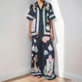 Black women's cardigan and trousers set with cartoon animation print, shown as a two-piece outfit.