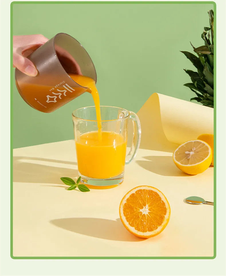 Green manual citrus juicer with lid and plunger, shown with lemons.