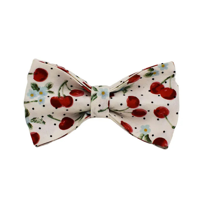 Red cherry print dog collar and leash set with light gold buckle, matching vest, bow, and poop bag holder.