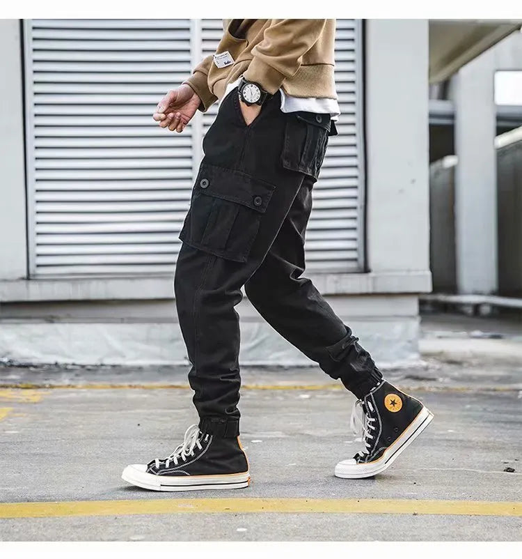 Men's black cotton overalls with loose cropped fit, ankle banded hem, and multiple pockets