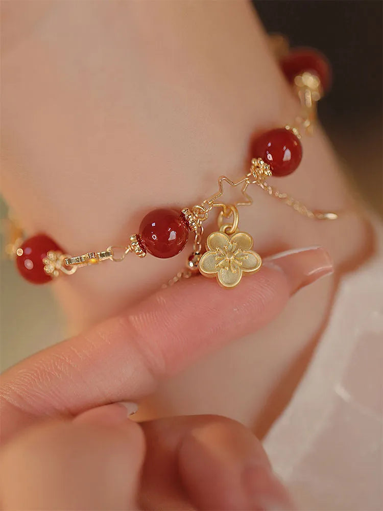 Women's double layer bracelet made from natural red agate with peach blossom decorations.