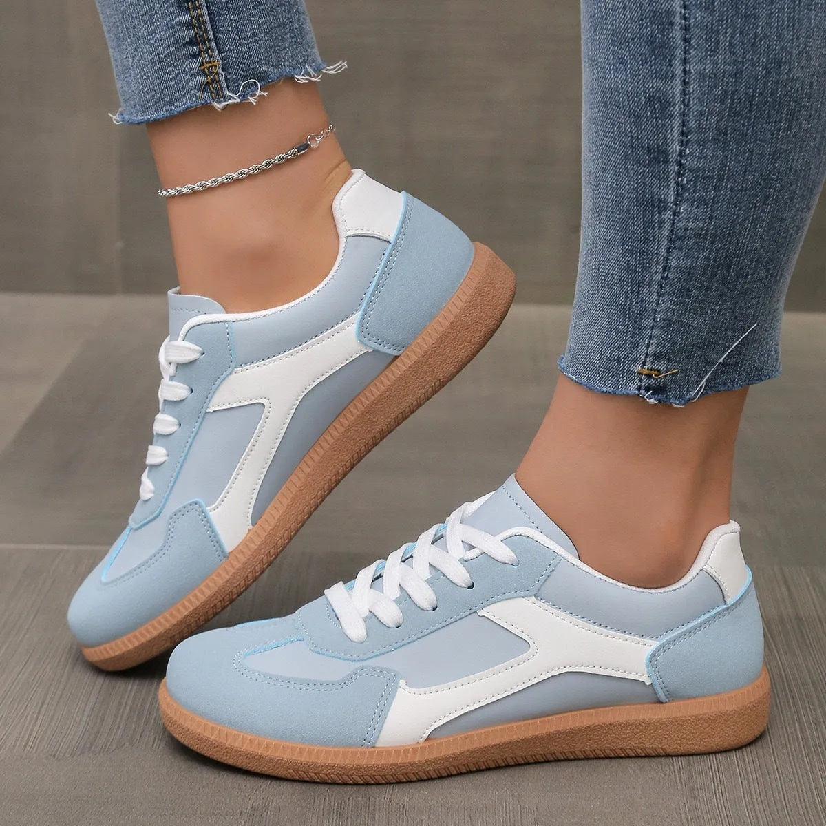 A pair of retro-style low-top lace-up sneakers in a selected colour on a plain background.