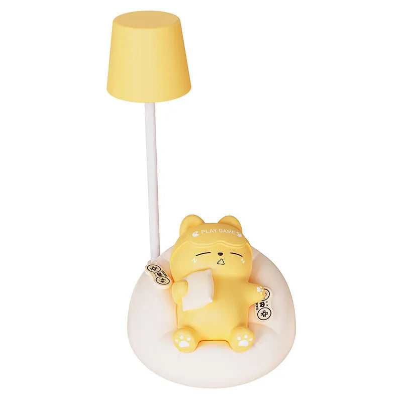 Sleeping cat shaped small night lamp in pink with USB charging cable on bedside table
