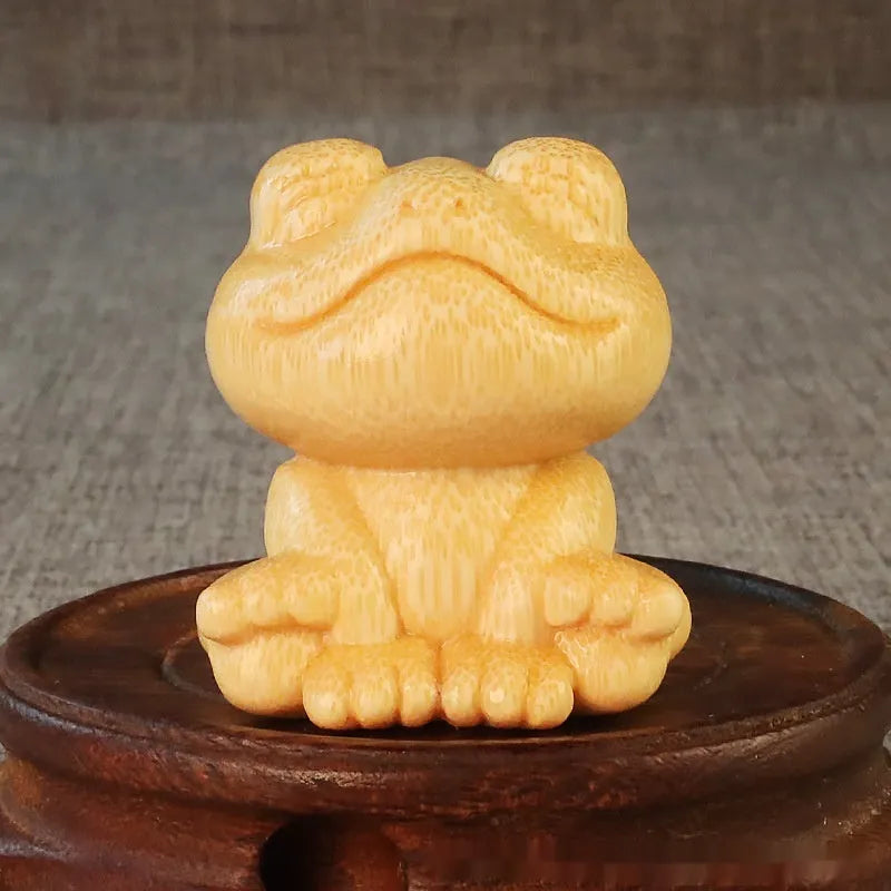 Solid bamboo carved ornament of a smiling cartoon frog, 5cm tall.