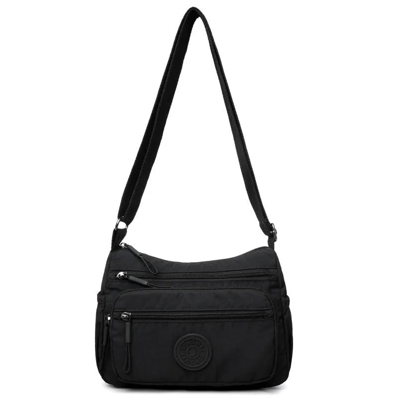 Grey water-repellent nylon crossbody bag showing outer pocket and internal organiser compartments.