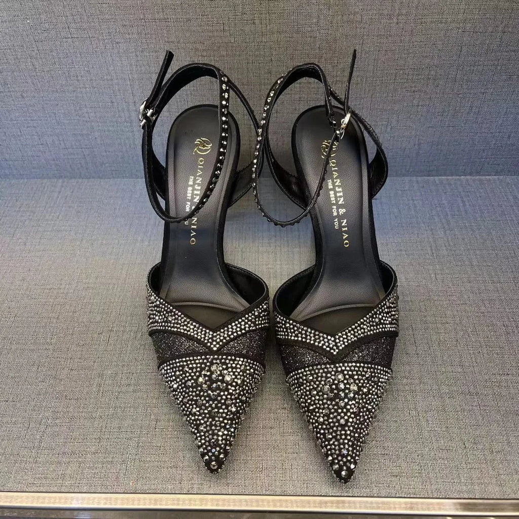 Black women's stiletto high heel shoe with a pointed toe and a bright red sole.