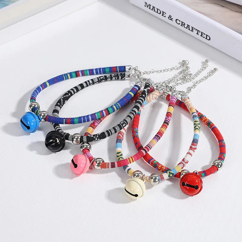 An adjustable ethnic-style pet collar with a metal buckle and bell, shown in various colours.