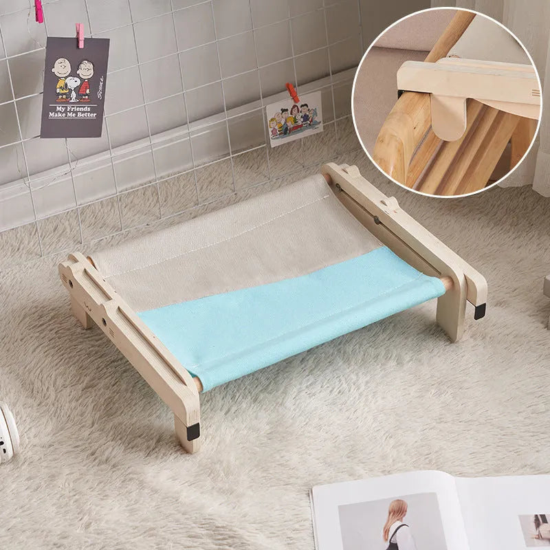 Solid wood cat bed with a removable plaid cushion on a wooden frame.