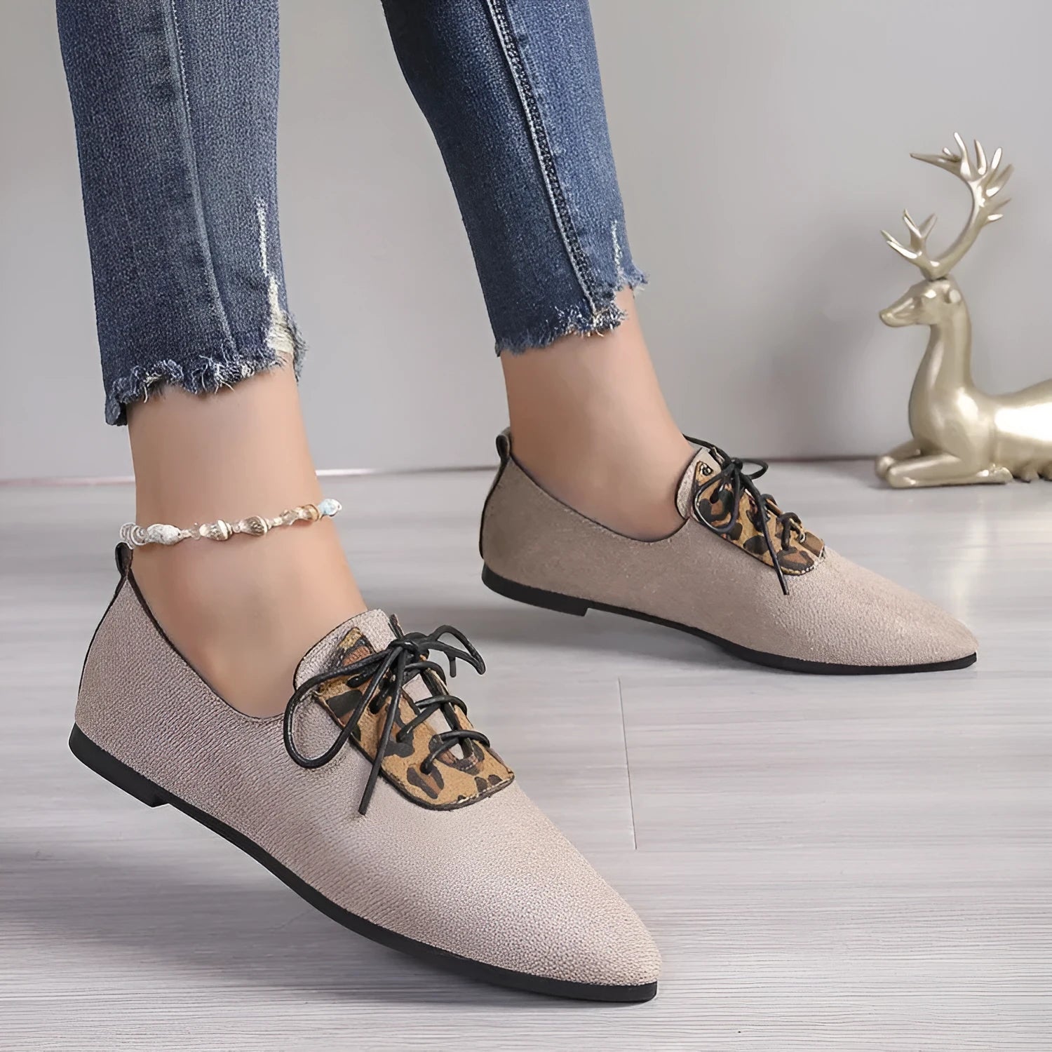 Beige leopard print women's pointed toe pumps on a white background.