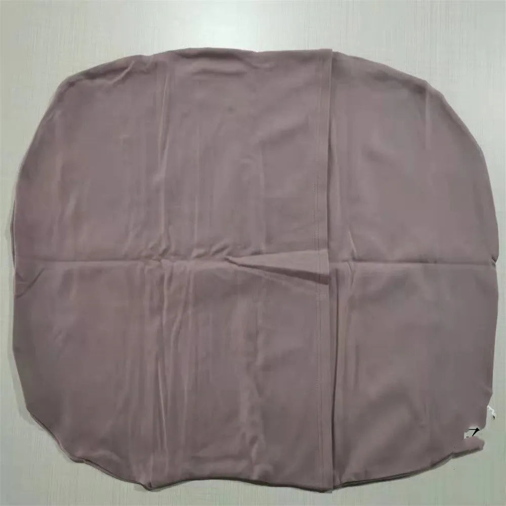 Cotton portable baby nest crib for newborns, beige colour, shown on a bed.