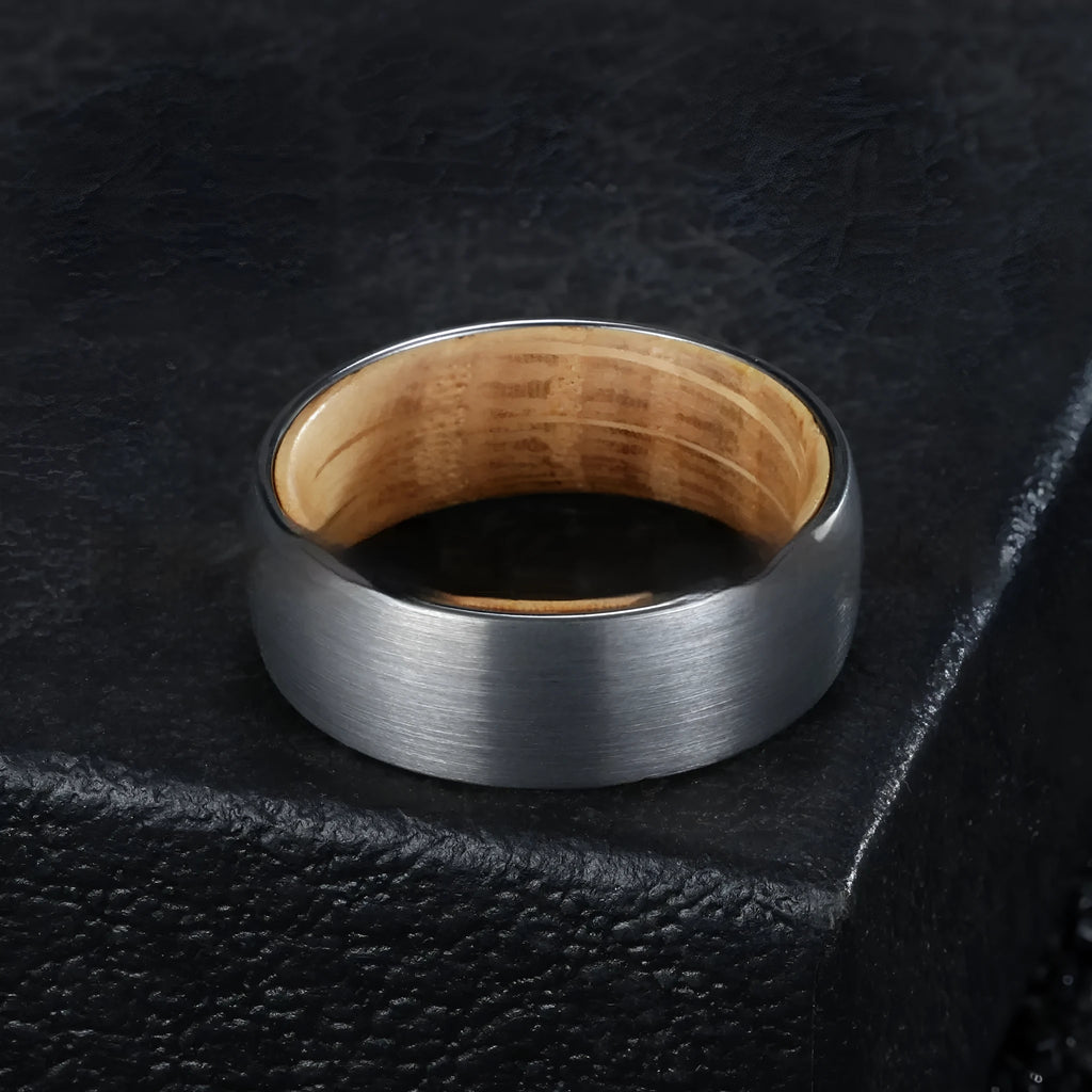 Silver tungsten ring with barrel wood inlay for men, simple band on light background