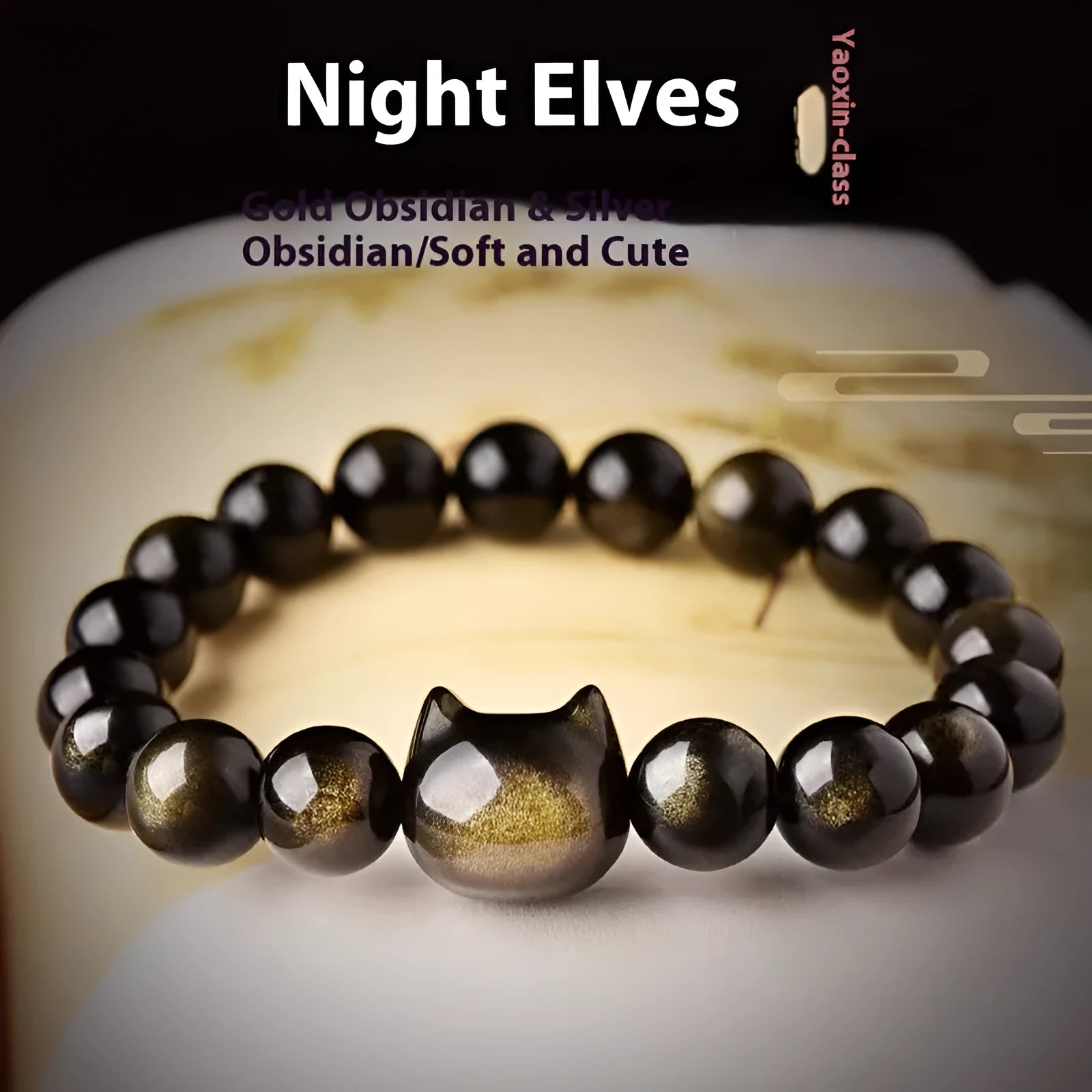 Obsidian cat head bracelet with round beads in gold or silver style, showing cat charm detail.