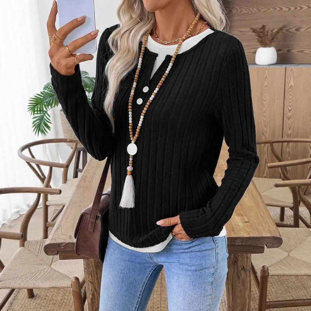 Women's black two-piece style pullover sweater with round neck and button detail on long sleeves.