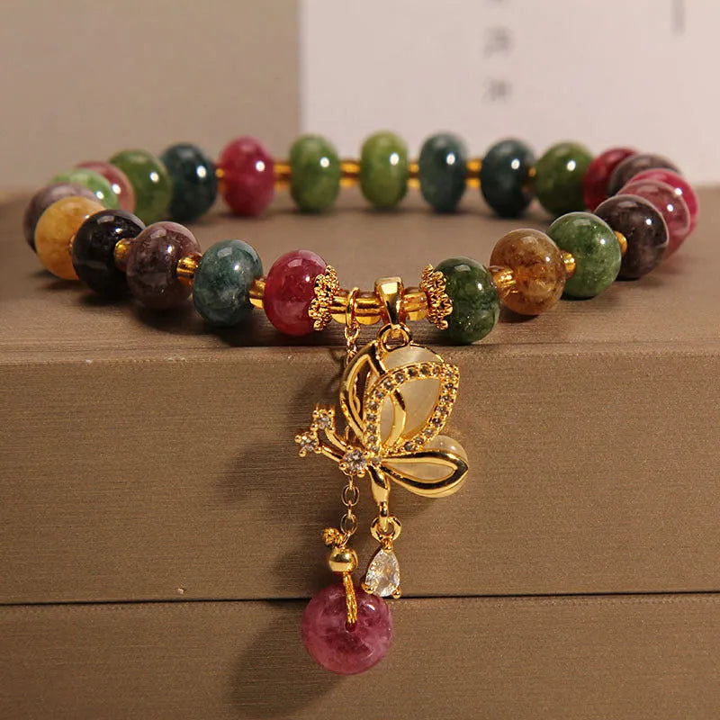 Colourful women's bracelet with a silver butterfly charm, colourful beads, and green tourmaline stones.