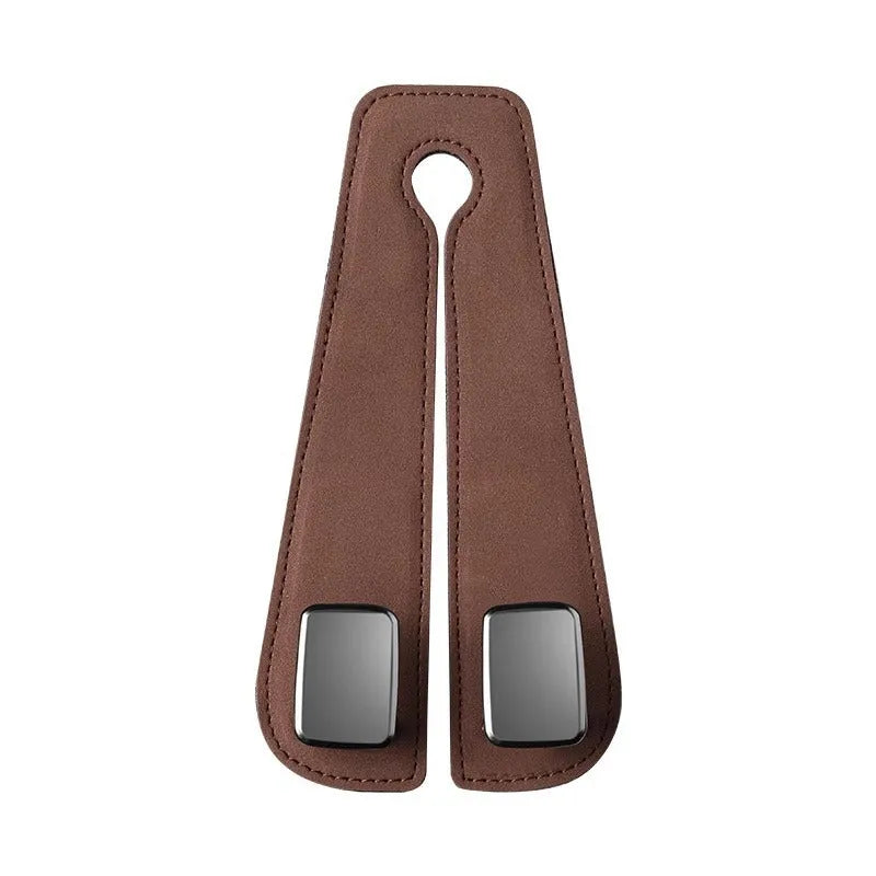 Black suede and metal car seat hook organiser hanging on a car headrest.