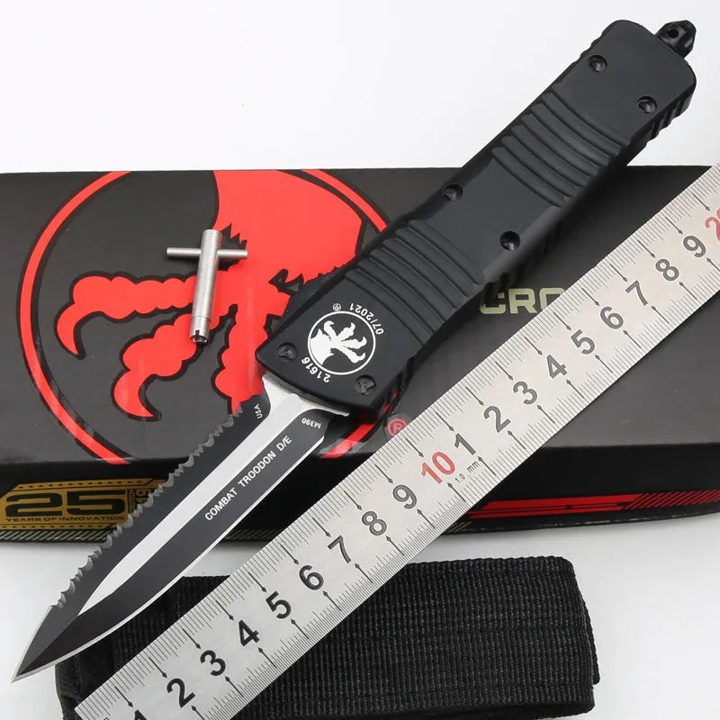 Black folding knife with D2 steel blade and aviation aluminium handle open on a dark surface