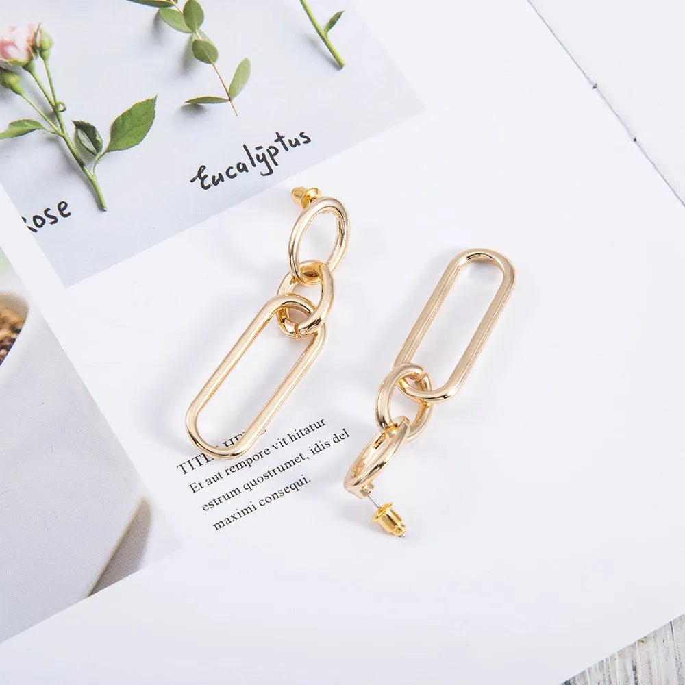 Geometric sterling silver colour hoop earrings with a ring and line design on a white background.