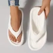 A pair of women's thick-soled flip-flops in grey, showing the EVA material and non-slip footbed texture.