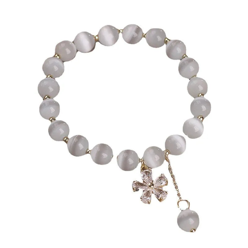 Women's white cat's eye bracelet with flower tassel and safety buckle pendant
