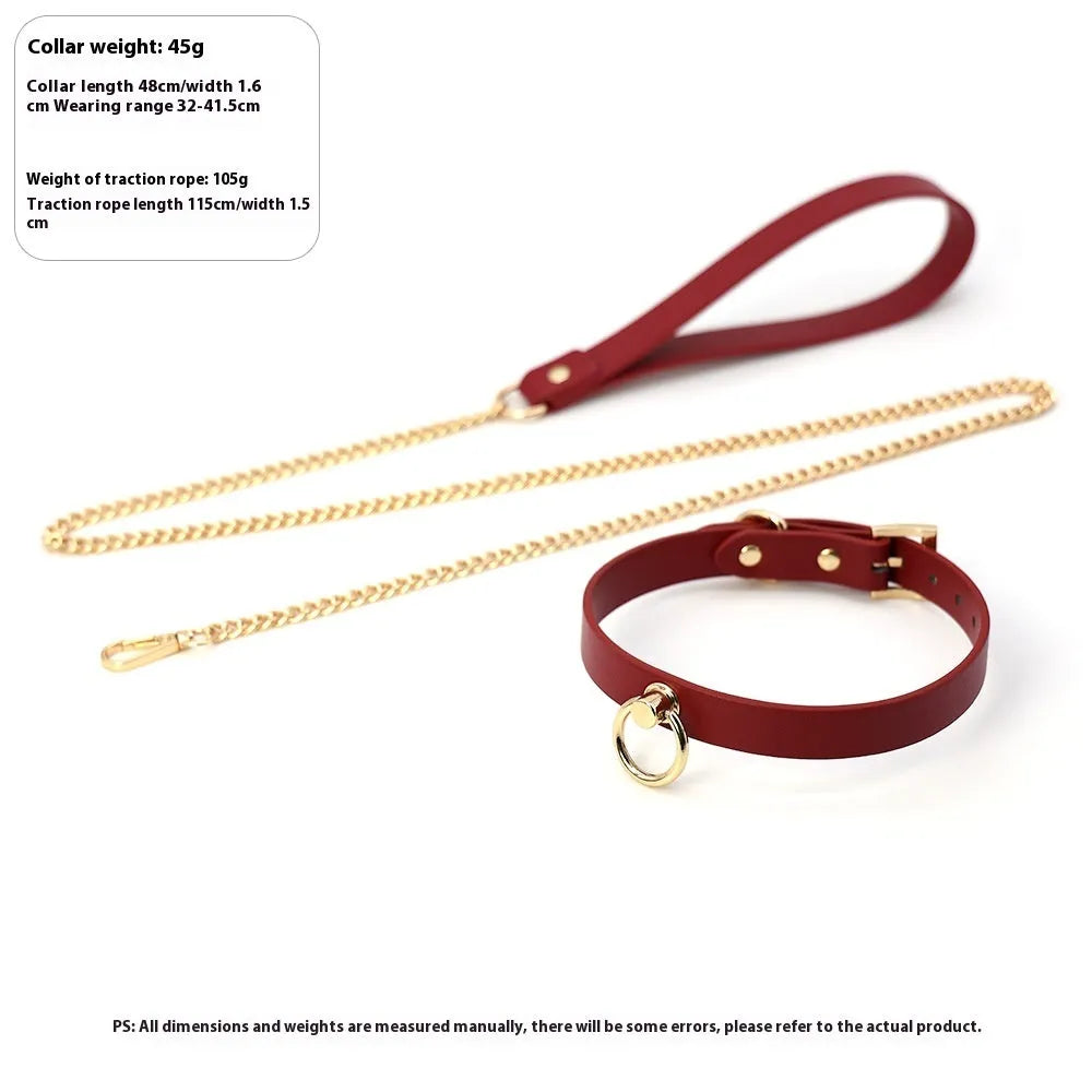 Genuine cowhide leather collar with metal fittings and a connected pull lead on a dark surface.