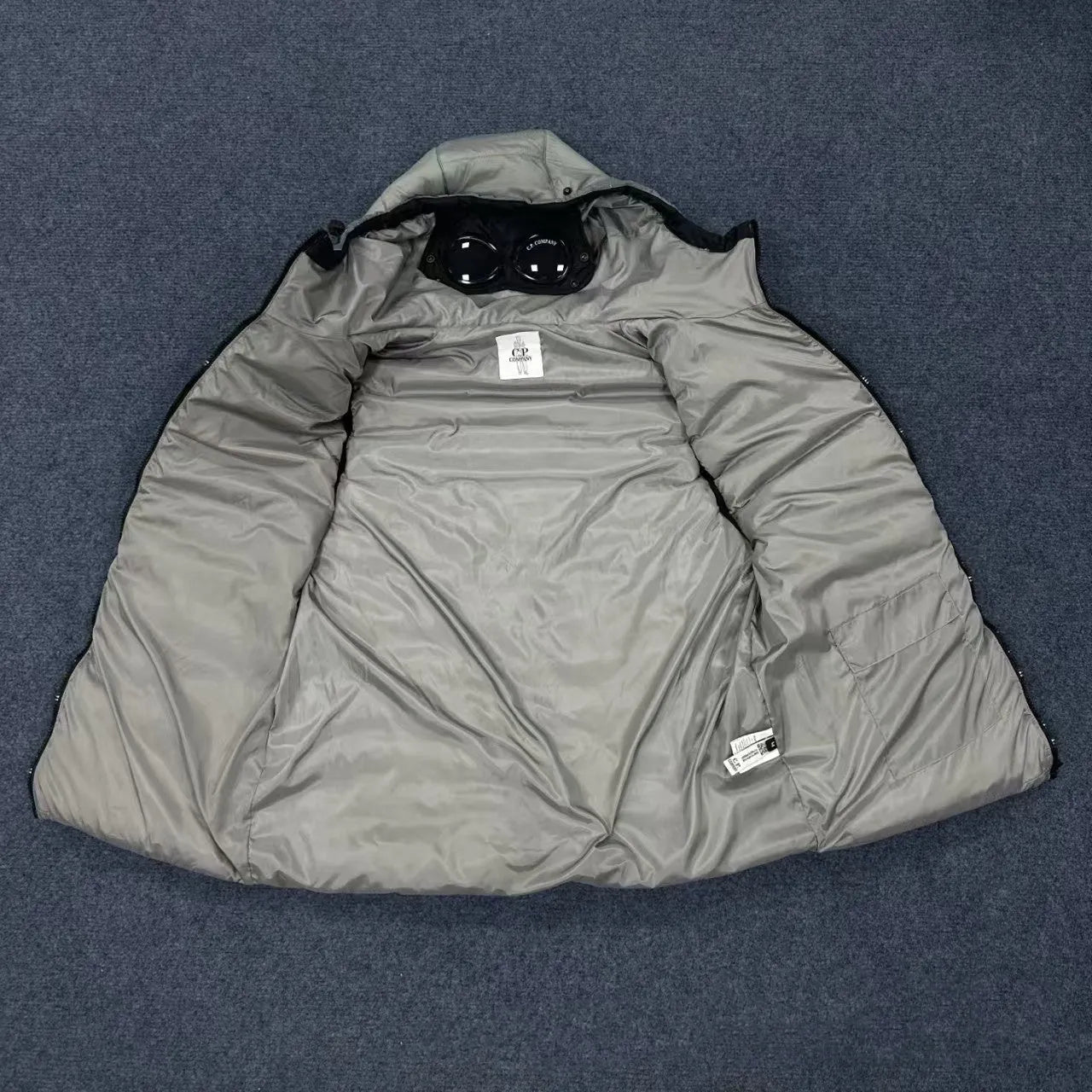 Men's loose hooded cotton vest jacket in black, side view, showing hood and zip closure