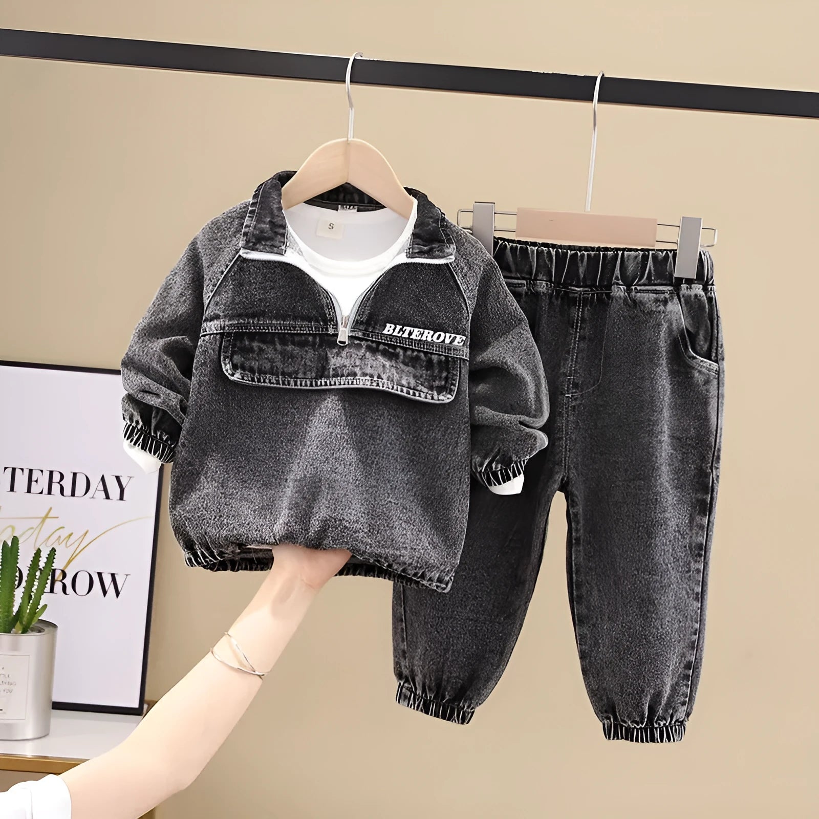 Boy wearing a black denim two-piece suit set with long sleeves, Korean style.