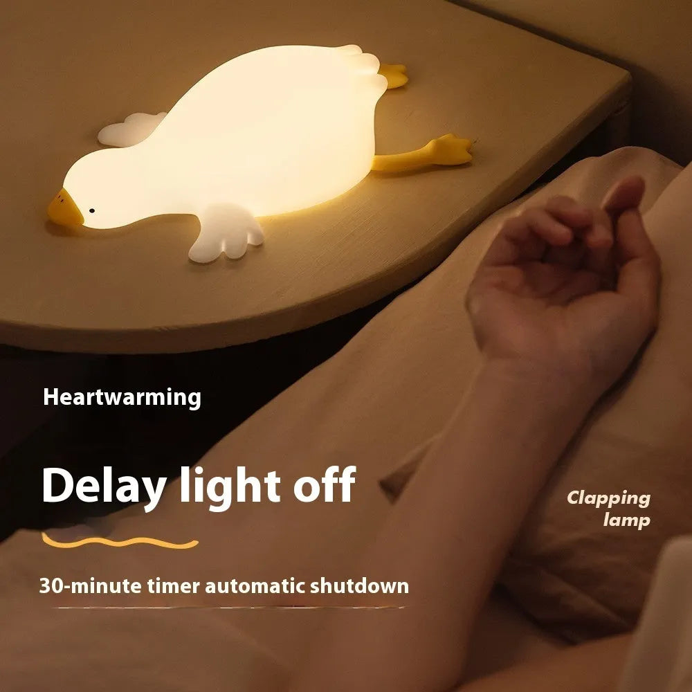 Big White Geese night light with warm white glow and silicone exterior on bedside table