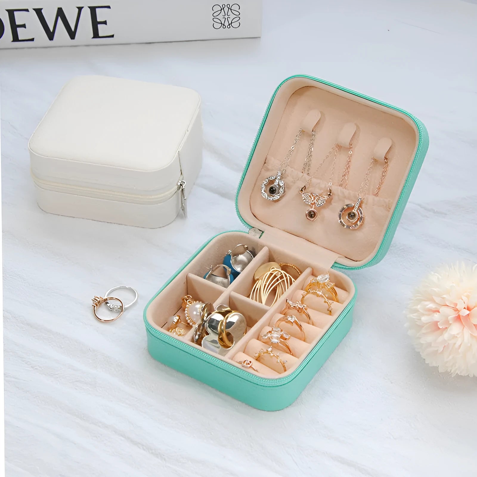 Small leather jewellery box in cross pattern, 10cm size, for earrings and rings, on a flat surface.