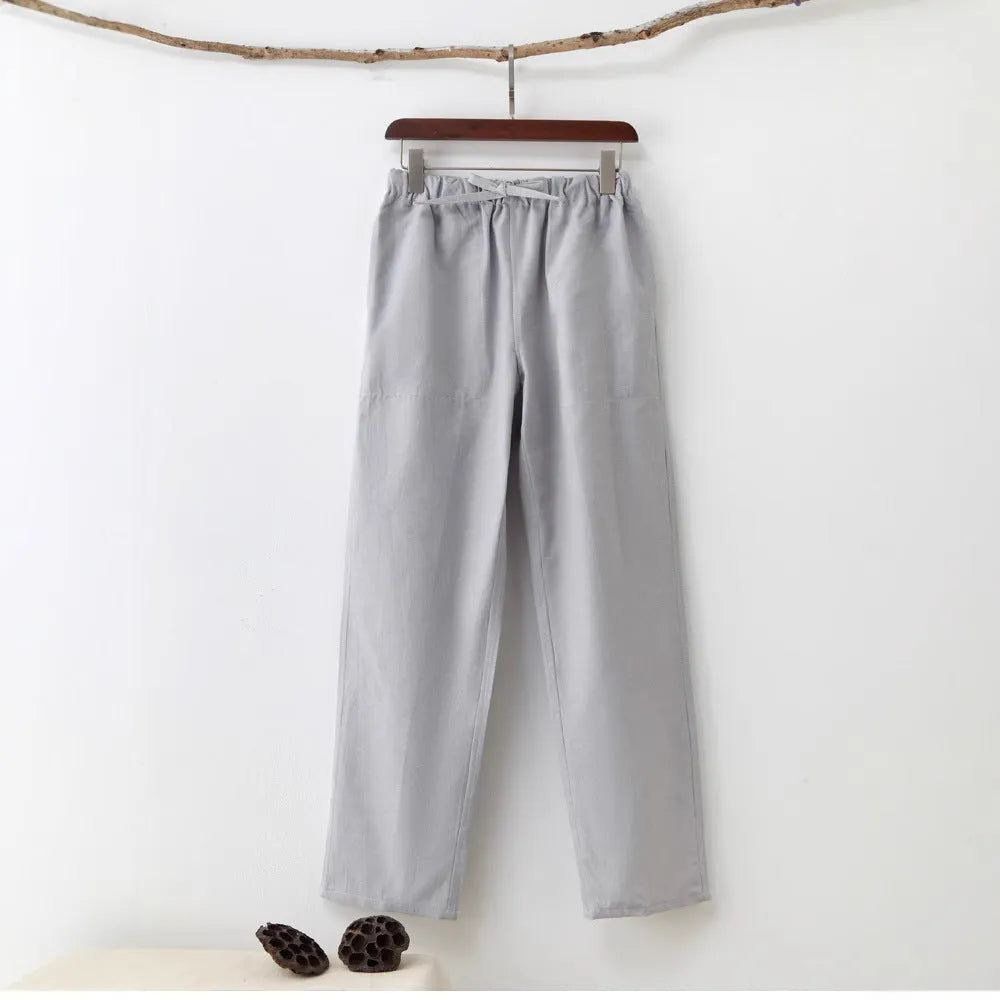 Man wearing beige pure cotton casual trousers with a drawstring waist and belt.