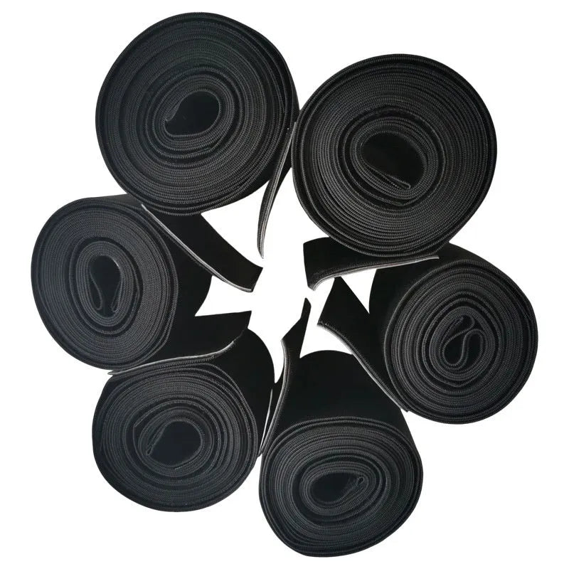 A long roll of a black latex silk waist trainer restraint belt, showing its 10cm width, laid flat.