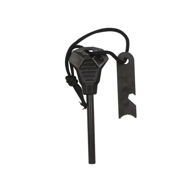 Black outdoor survival flint tool with magnesium rod, stainless steel scraper, whistle, and measurement scale.