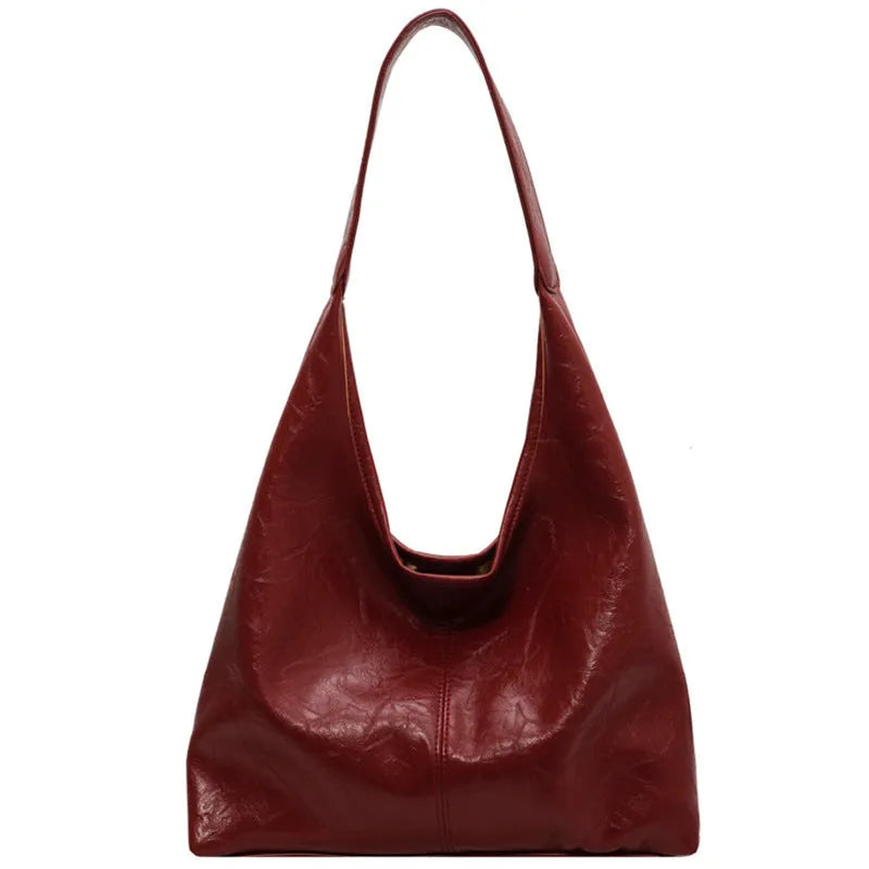 Soft black PU leather shoulder bag with large compartment and adjustable strap on a plain background.