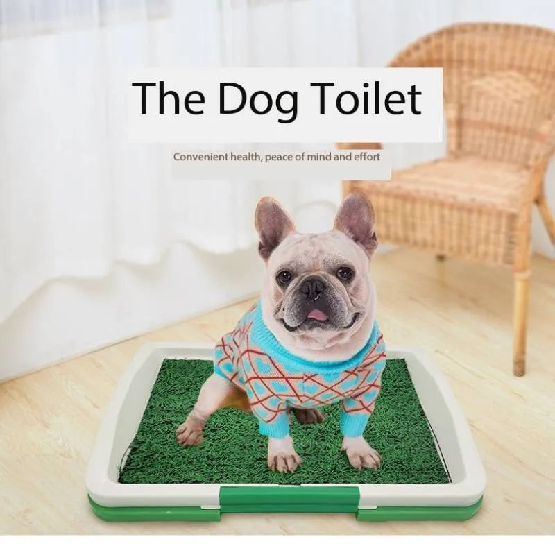 Green artificial grass indoor dog toilet tray with drainage holes and absorbent pads for puppy training.