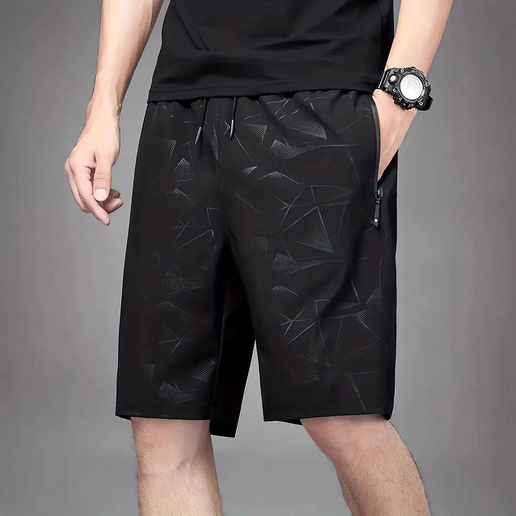 Man wearing loose fit black polyester sports shorts with elastic waistband