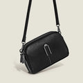 Minimalist crossbody bag in top-grain leather, horizontal square shape, available in five colours including khaki and black