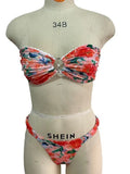 Women's floral print tube top bikini set with lace detailing on a blue background.