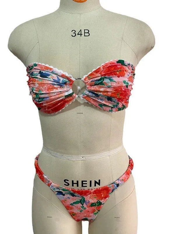 Women's floral print tube top bikini set with lace detailing on a blue background.