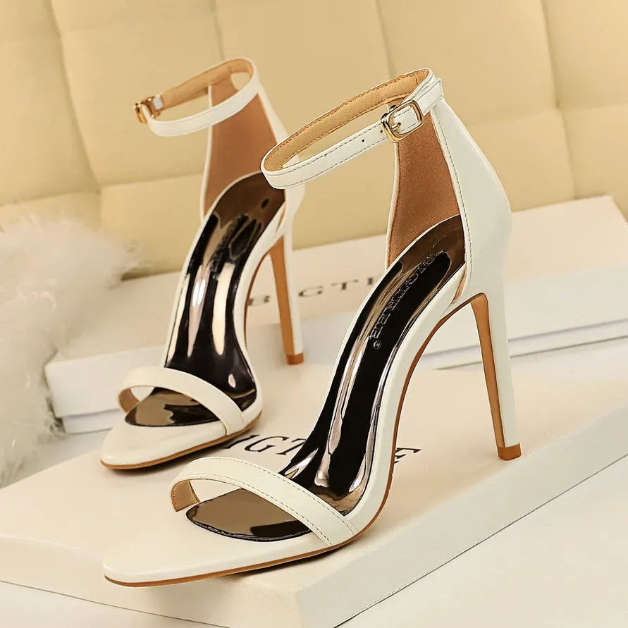 Open toe high heels with an ankle strap and buckle in a choice of six solid colours.