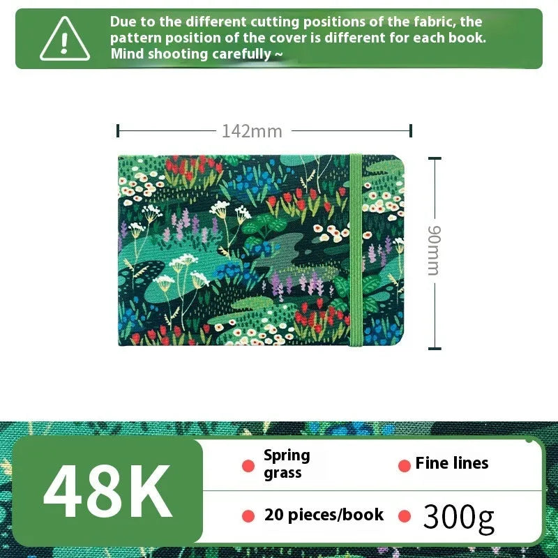 Feiluniao handmade fabric watercolour notebook with illustrated cover, open to show blank paper pages.
