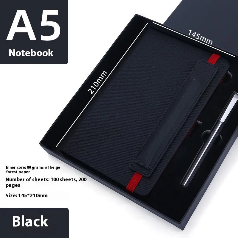 A5 faux leather notebook with pen insert and strap, open on a desk showing lined pages