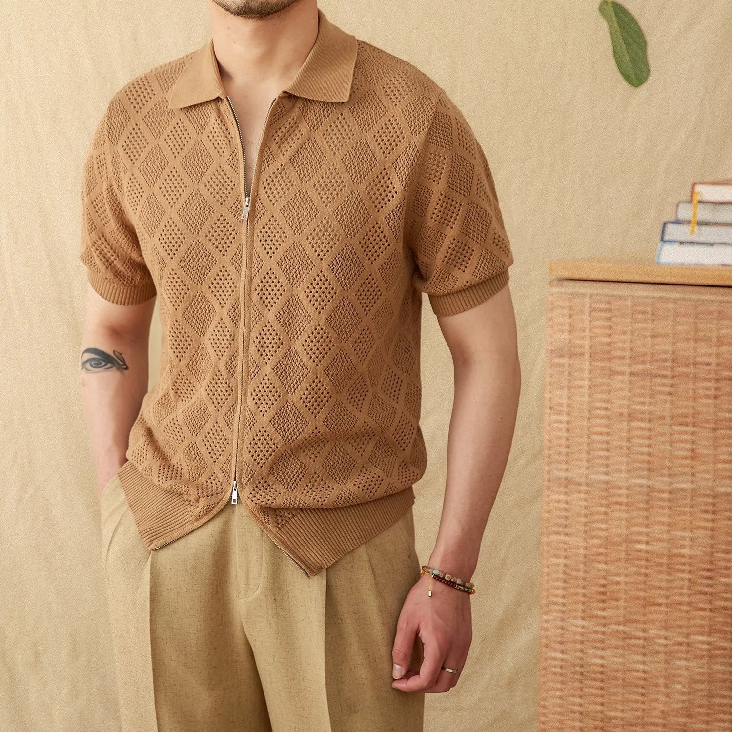 Light brown cotton short sleeve cardigan with a front zipper and lapel collar laid flat.