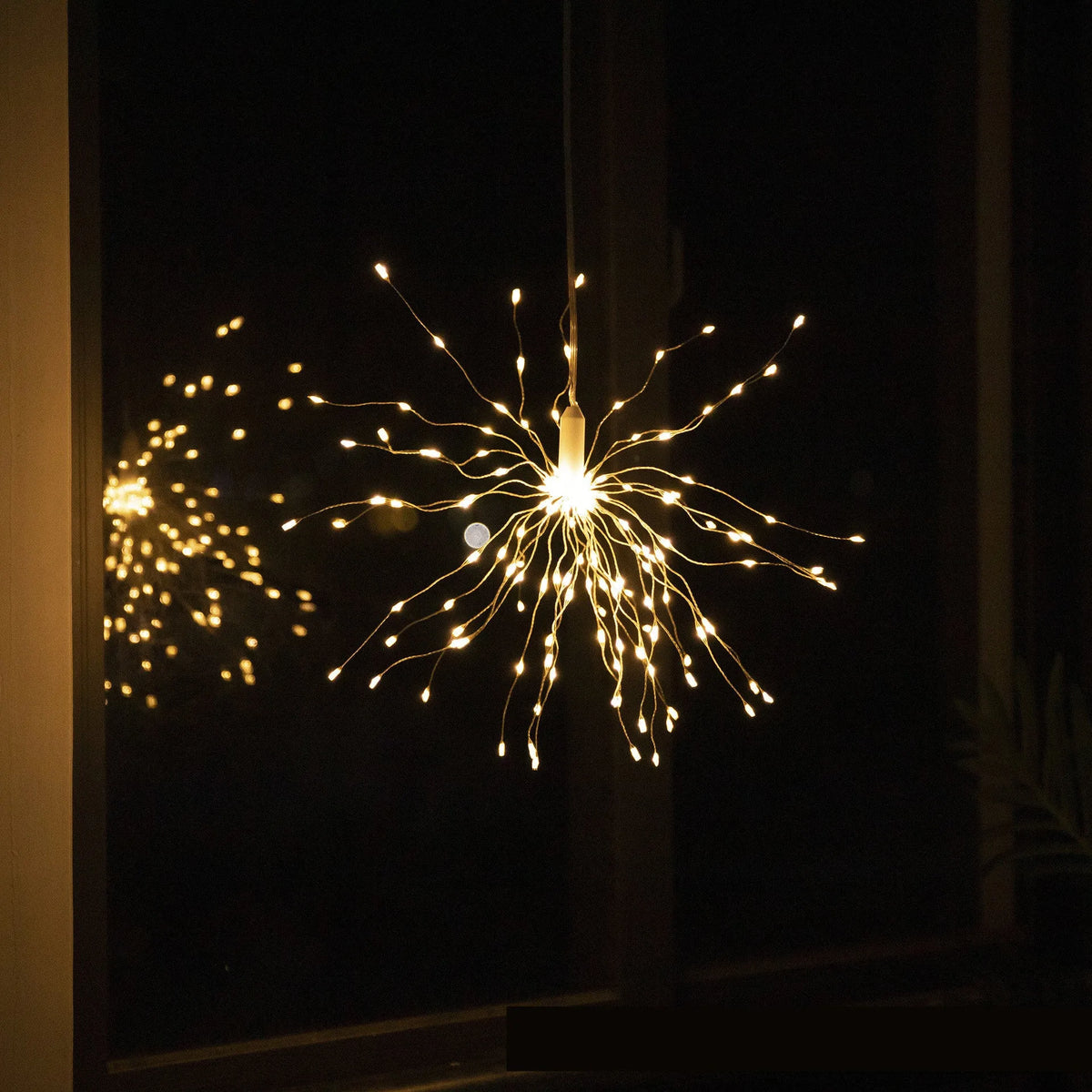 Outdoor waterproof dandelion string lights with warm colour glow on a garden fence