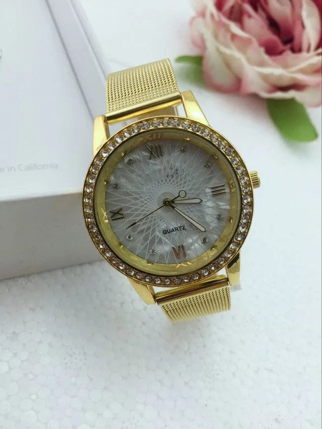 Golden mesh strap alloy electronic watch with round dial and world time GMT functions on a plain background
