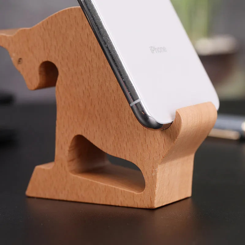 Beech wood and resin lazy bracket mobile phone holder in an animal design style on a desk.