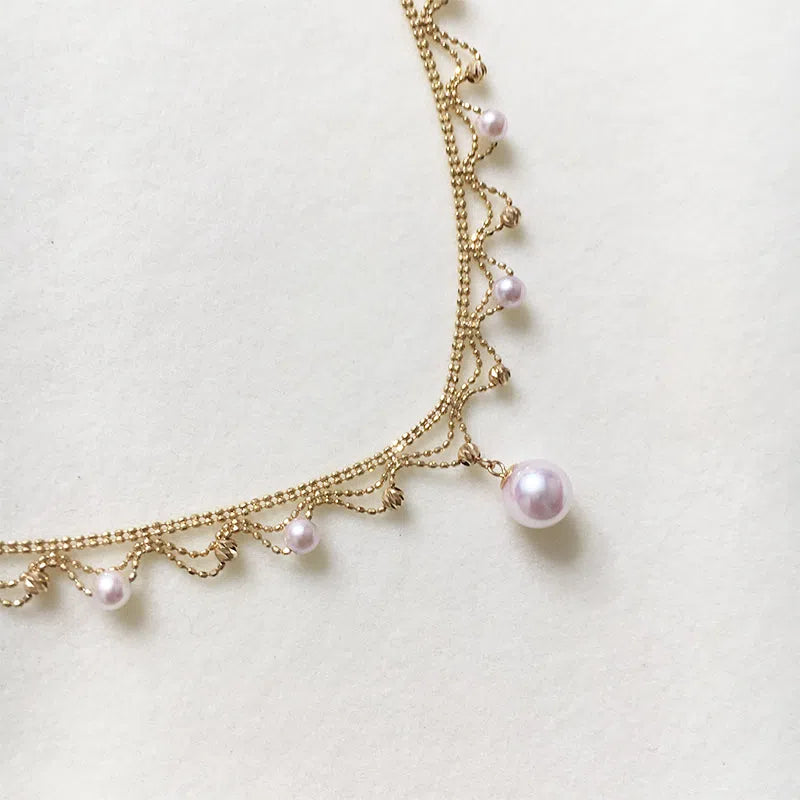 Aurora Japanese 18k gold lace pearl necklace with round sea pearl and gold finish on display