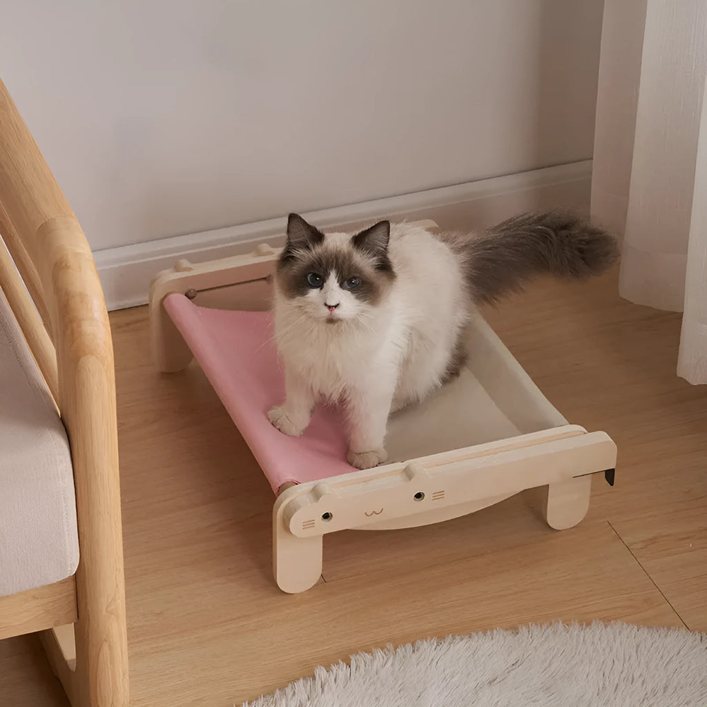 Solid wood cat bed with a removable plaid cushion on a wooden frame.