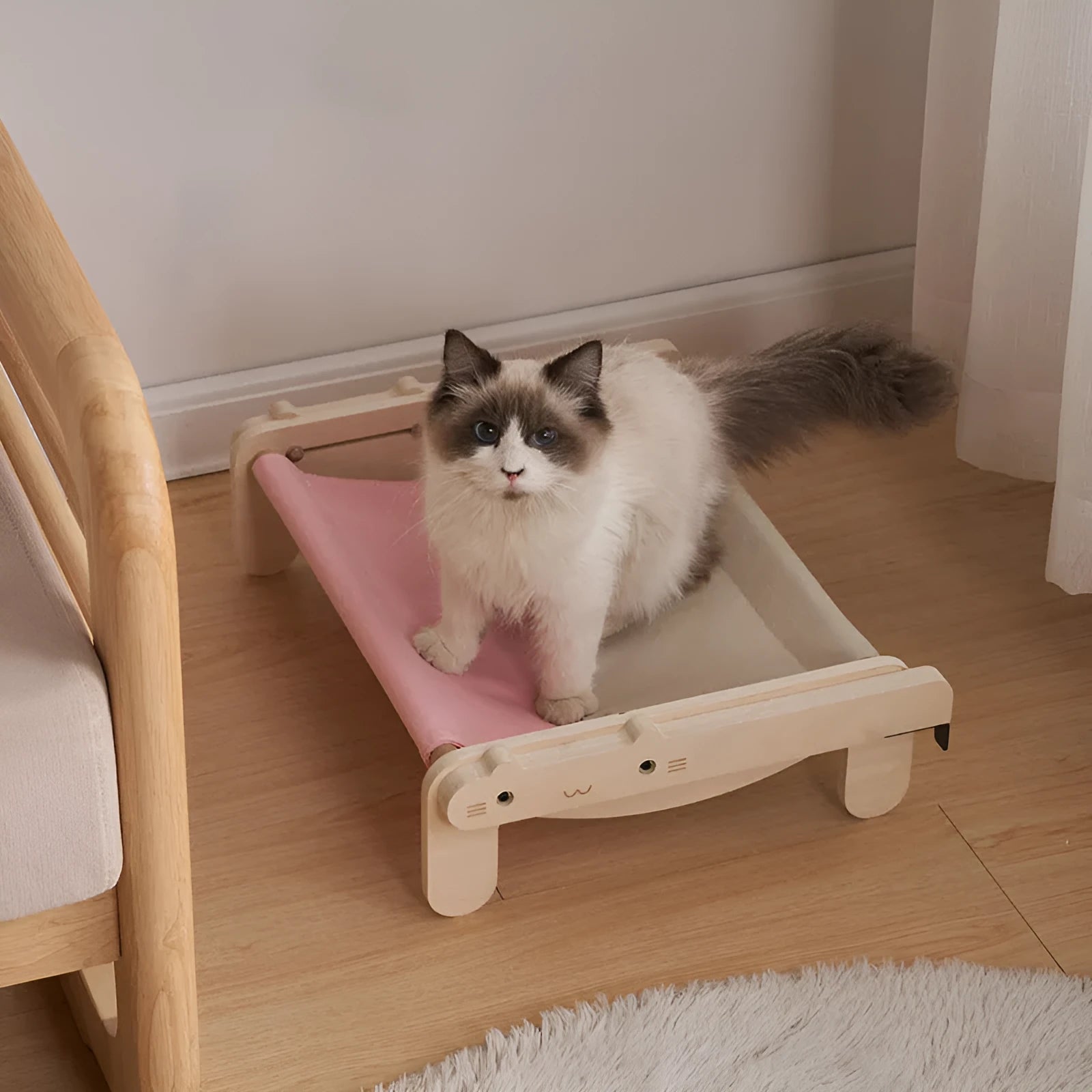 Solid wood cat bed with a removable plaid cushion on a wooden frame.