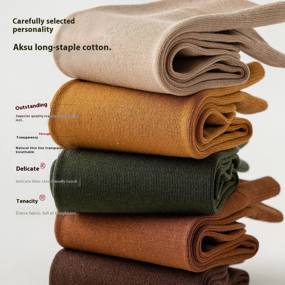 Five pairs of men's solid colour mid-calf socks made from combed cotton, shown in assorted shades.